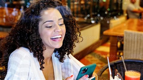 Femme Latine Assise Dans Un Café Avec Un Téléphone Portable Buvant Du Café Et Regardant Ailleurs
