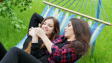 Two Beautiful Lesbian Women Feel Shy Sitting On A Bench And Join Hands Stock Video Video Of