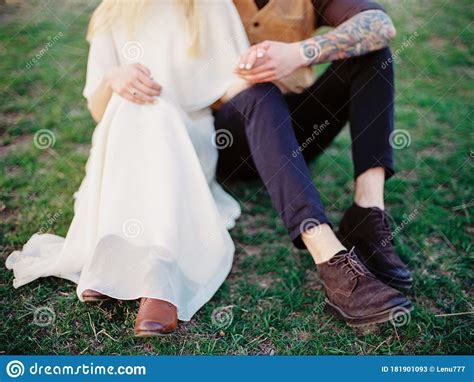 Country Wedding Outdoor Portrait Of Happy Beautiful Newlyweds Sitting On Green Grass Stock