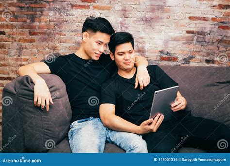 Asian Gay Couple Watching And Looking At Phone Tablet Together Portrait Of Happy Gay Men