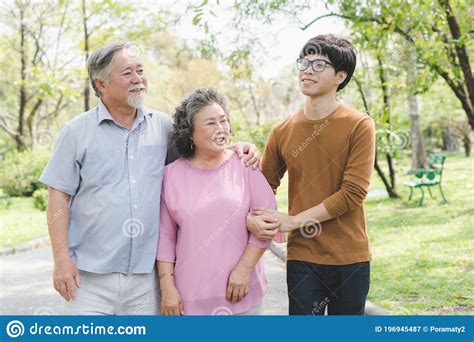 Familia De Asia Feliz Abuelo Cuida A La Abuela En El Parque Imagen De
