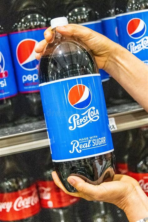 Shoppers Hand Holding A Plastic Bottle Of Pepsi Cola Soda Made With