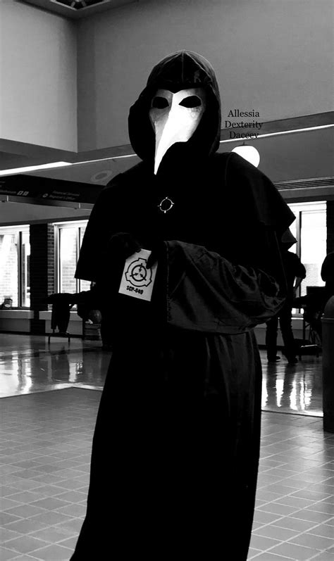 A Person In A Black Robe With A Mask On Their Face And Hood Over His Mouth