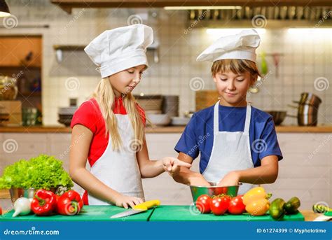Szczęśliwy Uśmiechnięty Szef Kuchni Dziewczyny I Chłopiec Przygotowywać Zdrowy Obraz Stock