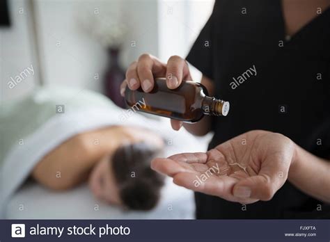 Massage Therapist Applying Oil To Hand Stock Photo Alamy