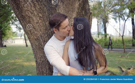 Interracial Couple Share Tender Kiss Under A Tree In Benchakitti Park