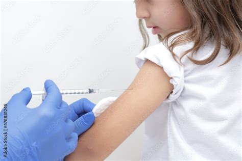 Zdjęcie Stock Criança tomando vacina no braço com prevenção do covid e medico com luva azul