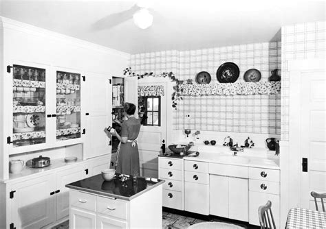 An Old Black And White Photo Of A Woman In The Kitchen