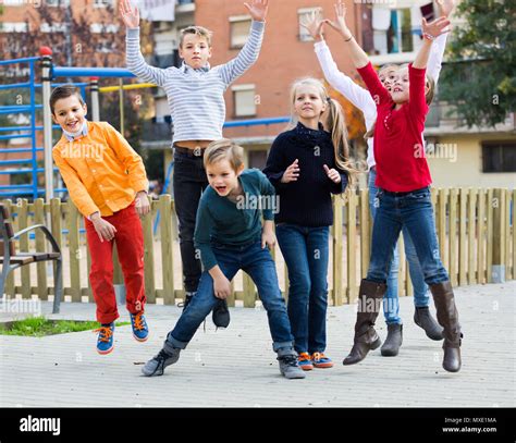 Group Of Cheerful Kids In High Spirits Jumping Outdoors Stock Photo Alamy