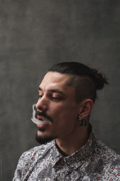 Man With Mohawk Hairstyle Blowing Smoke Del Colaborador De Stocksy