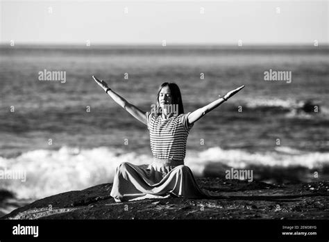 Yoga Woman Meditates In The Lotus Position Sitting On Rocks On The