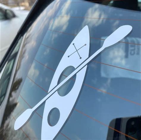 An Image Of A Kayak Sticker On The Side Of A Car Door Window