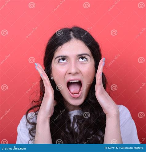 Portrait Of Angry Girl Screaming Against Red Background Stock Photo