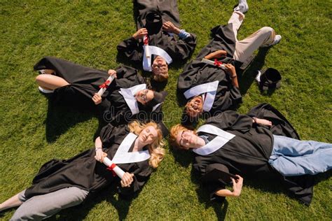 Graduates Lying Together On The Grass Lawn Stock Photo Image Of