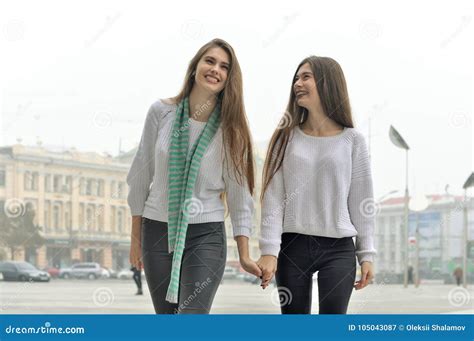 dos novias están caminando a través de la ciudad llevando a cabo las manos y imagen de archivo