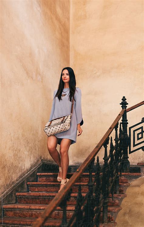 stylish woman comes down the stairs by stocksy contributor lumina stocksy