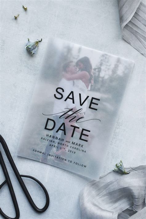A Wedding Save The Date Card With Scissors Next To It On A White Tablecloth
