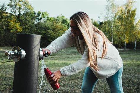Premium Photo Blonde Girl Fills Water In A Recycled Bottle