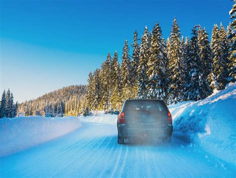 Car Driving On A Snow Covered Road In A Wilderness Forest Stock Photo