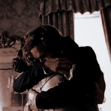 A Man In A Suit And Tie Hugging Another Man