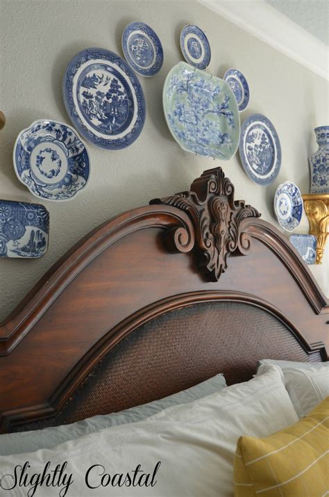A Bed With Blue And White Plates On The Wall Above It