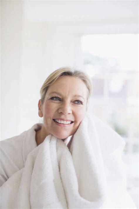 Smiling Mature Woman Drying Face With Towel Stock Photo