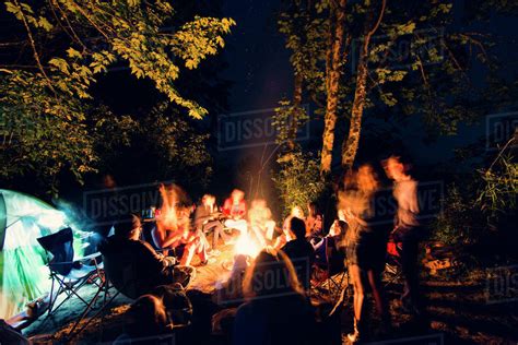 Friends Sitting Around Campfire In Forest Stock Photo Dissolve