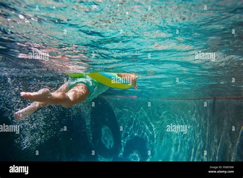 Underwater Shot Of Girl Kicking Legs In Swimming Pool Learning To Stock