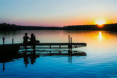 Royalty Free Photo Silhouette Of Two People Sitting On Docks Near Body