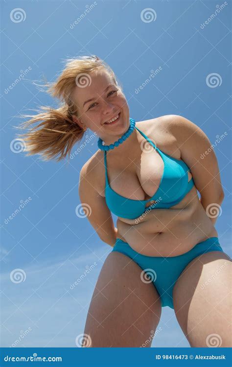 Overweight Woman In Blue Bikini Looks Down Royalty Free Stock Photo