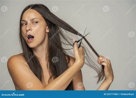 Une Femme Nerveuse Se Coupe Les Cheveux Avec Des Ciseaux Photo Stock