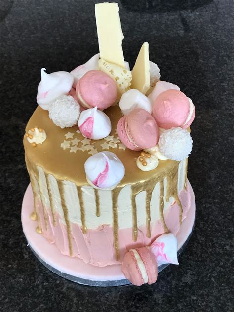 loaded pink and gold drip cake with french macarons and meringue kisses drip cakes cake pink