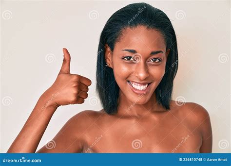 Joven Afroamericana Desnuda Sobre Un Fondo Sonriente Feliz Y Positivo Pulgar Arriba Haciendo