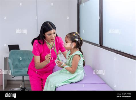 Female Doctor Examining A Girls Lungs With A Stethoscope While The