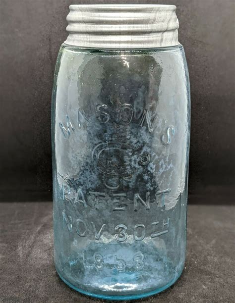 An Old Glass Jar With Some Writing On It