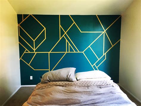 A Bed Sitting In Front Of A Green Wall With Yellow Lines Painted On The