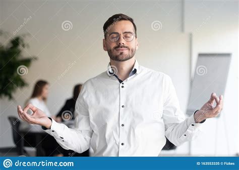 Calm Businessman Meditating With Eyes Closed In Office Stock Image