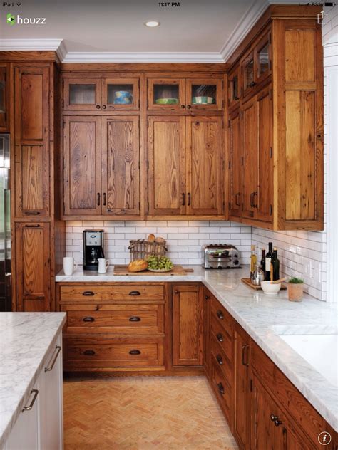 Rich Oiled Wood Shaker Cabinets With White Tile Backsplash And Marble