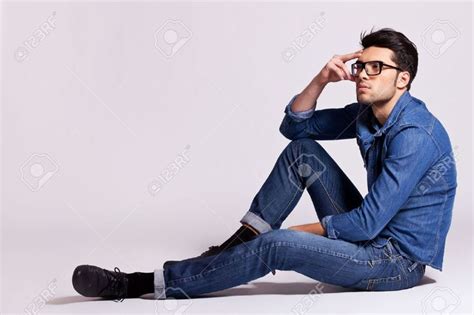 Side View Of A Casual Fashion Man Sitting On Gray Background