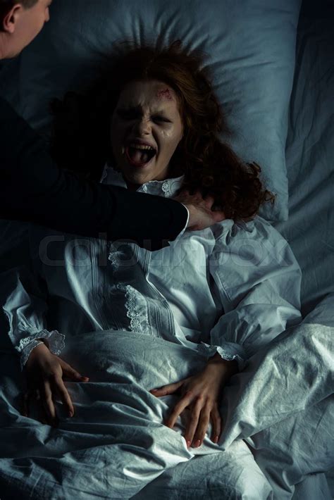 Exorcist Holding Yelling Female Demon In Bed Stock Image Colourbox