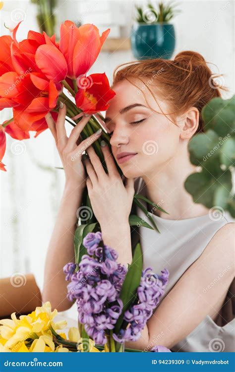 Portrait Of Woman Florist Holding Near Face Red Tulips Stock Image