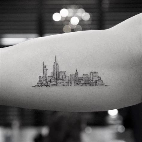 A Tattoo On The Arm Of A Person With A City Skyline In Black And White