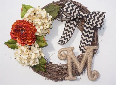 A Wreath With The Letter M And Flowers On It