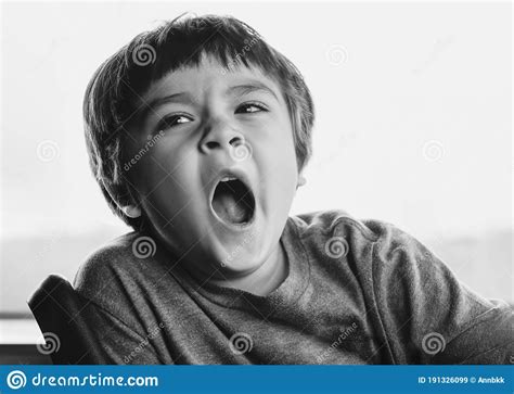 Close Up Face Of Kid Yawning Lying Sleepy Child Yawning And Looking