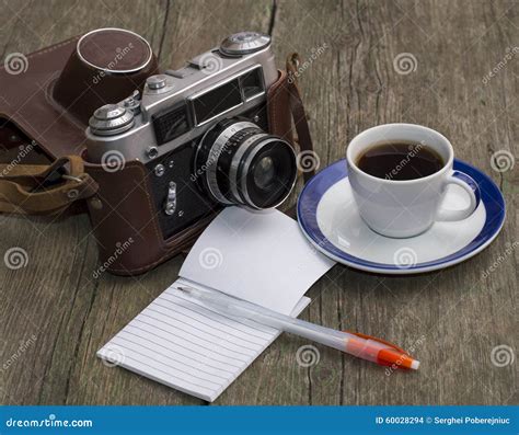 The Old Camera Coffee And Notebook With The Handle On A Wooden Stock