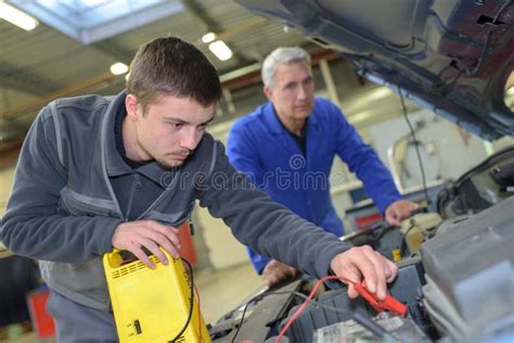 Apprentice Mechanic In Auto Shop Working On Car Engine Stock Image