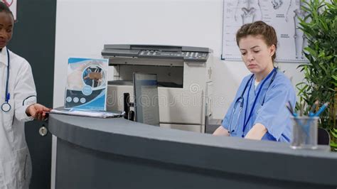 Medical Assistant Working At Hospital Reception Desk In Facility Stock