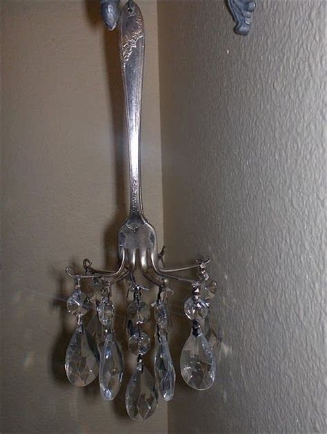 A Silver Wall Light With Crystal Drops Hanging From Its Arm And On The