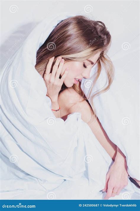 Sensual Woman Lying In Bed And Hiding Under The Sheet Stock Image
