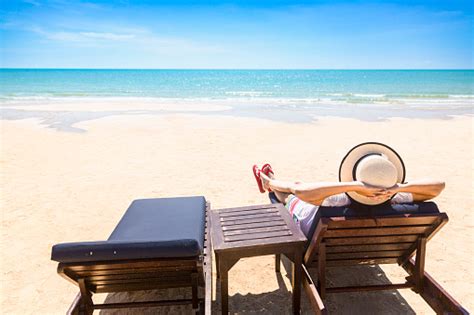 Woman Relaxing On Beach Lounge Chair Or Sun Deck With Sea View On Beach